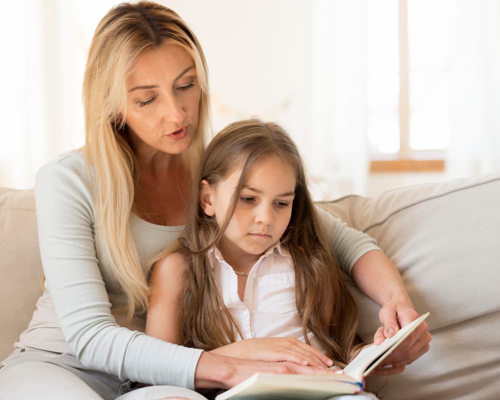 mãe e filha lendo conto em casa
